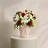 Luxury floral arrangement with red roses, white lilies, white lisianthus, and fresh greenery in an elegant decorative vase by Marino Flowers.