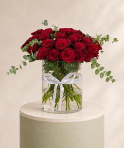 Luxury arrangement of premium red roses with fresh eucalyptus in a clear glass vase by Marino Flowers.