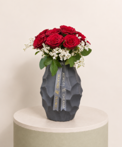 Luxury arrangement of premium red roses with white filler flowers in an elegant black vase by Marino Flowers.