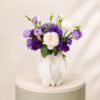 Elegant arrangement of peony roses and purple lisianthus in a luxury white decorative vase by Marino Flowers.