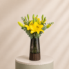 Elegant yellow lily arrangement with fresh eucalyptus in a luxury modern vase by Marino Flowers.