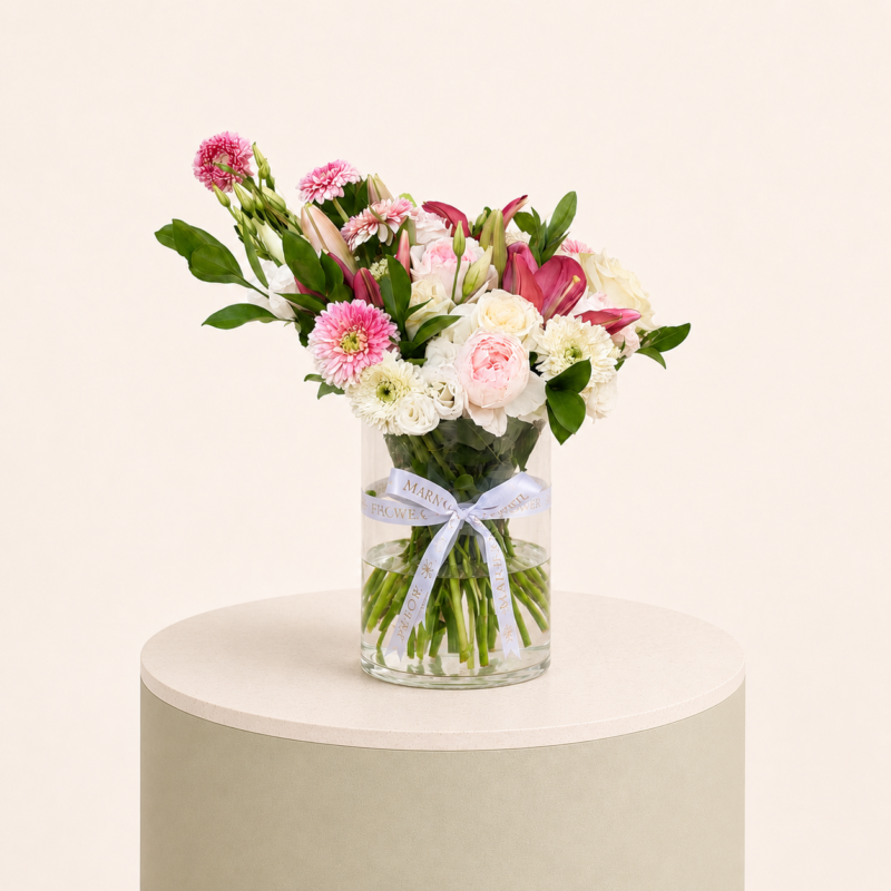 Luxury arrangement of pink lilies, blush roses, white roses, and pink gerberas in a glass vase by Marino Flowers.