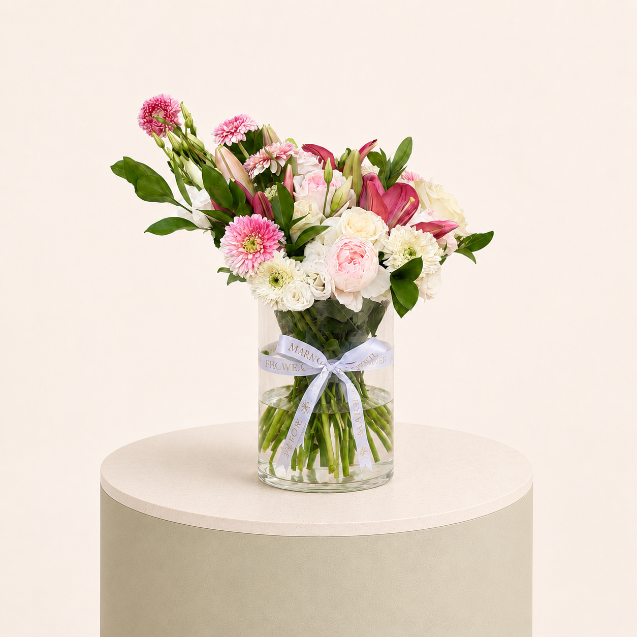 Luxury arrangement of pink lilies, blush roses, white roses, and pink gerberas in a glass vase by Marino Flowers.