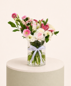 Luxury arrangement of pink lilies, blush roses, white roses, and pink gerberas in a glass vase by Marino Flowers.