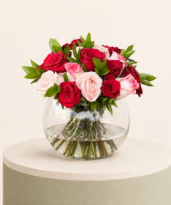 Luxury arrangement of red and blush pink roses in an elegant glass bowl vase by Marino Flowers.