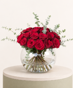 Luxury arrangement of premium red roses with eucalyptus in an elegant glass bowl vase by Marino Flowers.