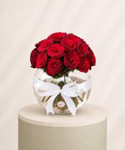 20 premium red roses arranged in an elegant glass bowl vase with a decorative white ribbon by Marino Flowers.