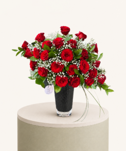 Luxury red rose arrangement with baby's breath and greenery in an elegant black vase by Marino Flowers.
