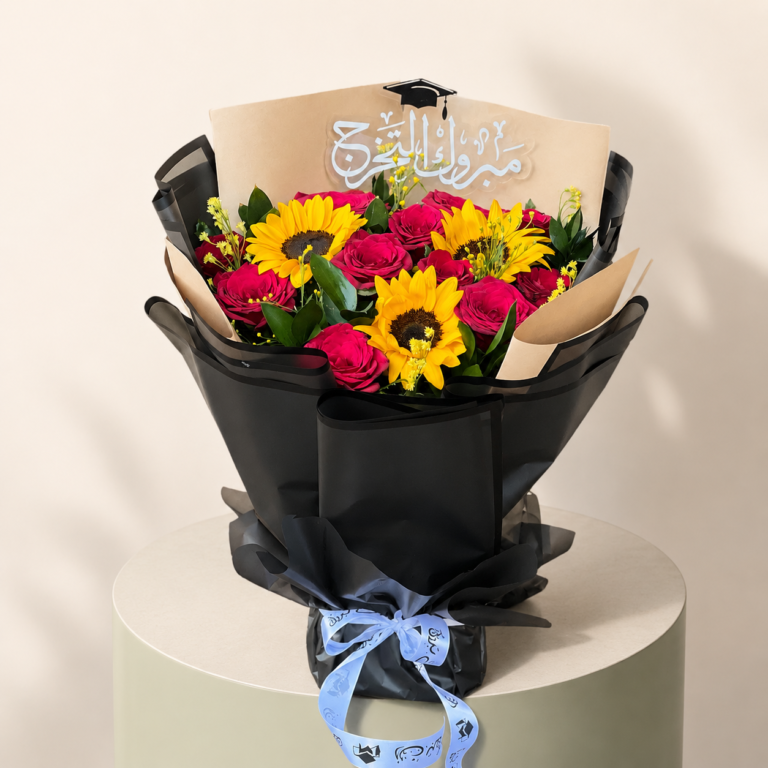 Graduation bouquet with red roses, sunflowers, black wrapping, and graduation topper by Marino Flowers