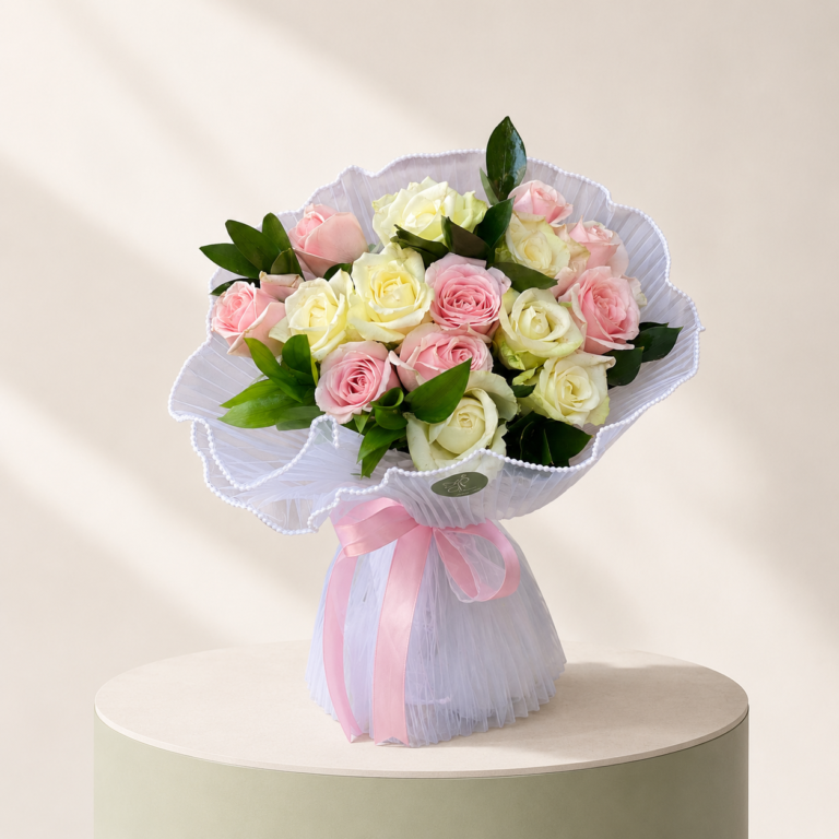 Pink and white rose hand bouquet with white tulle wrapping and pink ribbon by Marino Flowers