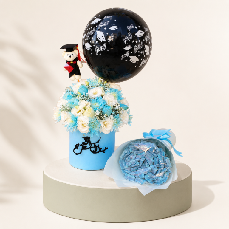Blue graduation flower box with white and blue flowers, graduation teddy, black balloon, and candy bouquet by Marino Flowers