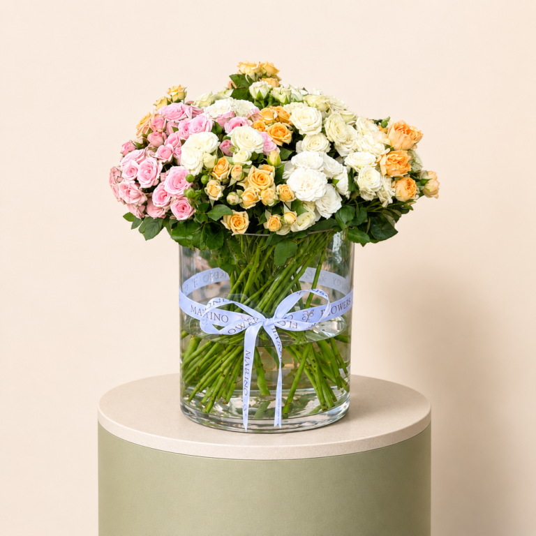 20 mixed baby roses in a medium clear glass vase with pastel pink white and peach flowers by Marino Flowers