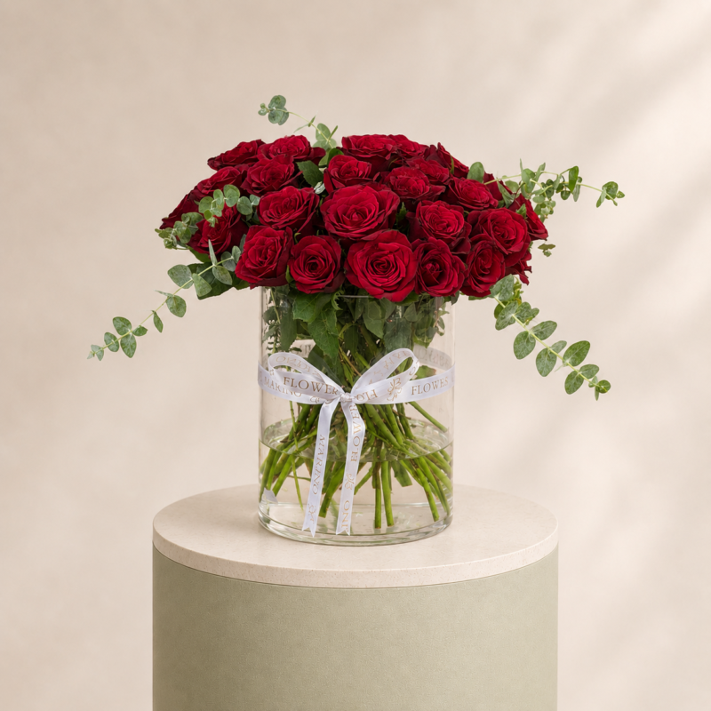 Luxury red roses with eucalyptus arranged in a clear glass vase by Marino Flowers