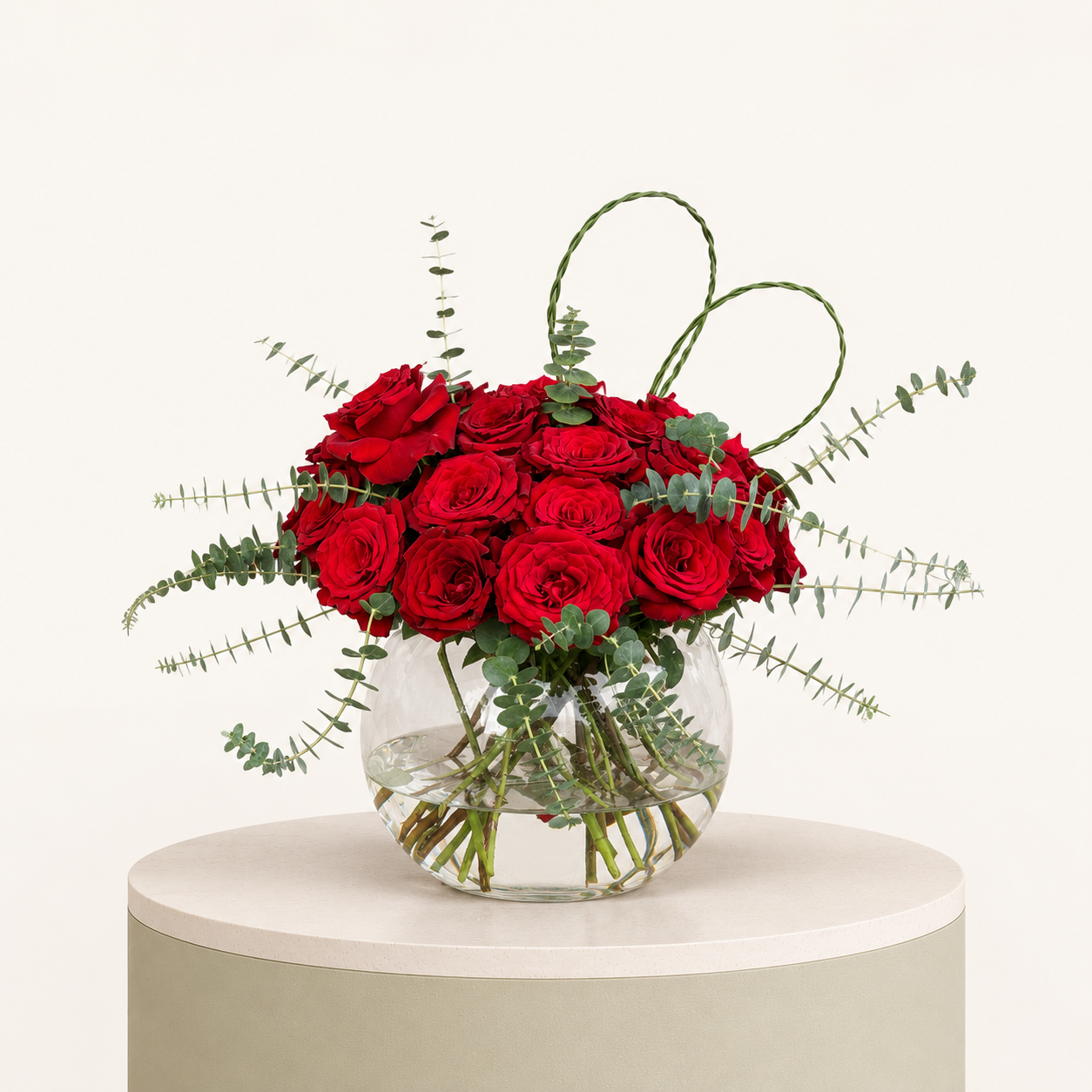 Luxury red rose arrangement with eucalyptus and heart-shaped greenery in a glass bowl vase by Marino Flowers.