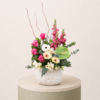 Luxury floral arrangement with pink roses, gerbera daisies, green anthurium, snapdragons, and eucalyptus in a decorative ceramic vase.