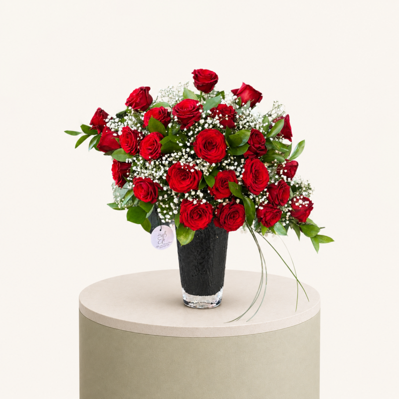 Luxury red rose arrangement with baby's breath and greenery in an elegant black vase by Marino Flowers.