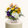 Luxury sunflower and lily arrangement with yellow roses, birds of paradise, and purple lisianthus in a ceramic vase.