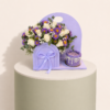 Purple floral gift box with white and purple flowers and mini cake by Marino Flowers