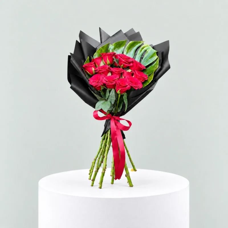 12 red roses bouquet with black wrapping and red ribbon by Marino Flowers.