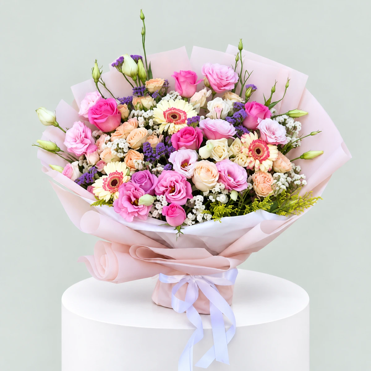 Blush Meadow – Pink Roses & Lisianthus Bouquet | Marino Flowers Medium-to-large pink mixed flower bouquet with roses, lisianthus, peach spray roses, pastel gerberas and purple fillers in blush-pink wrapping.